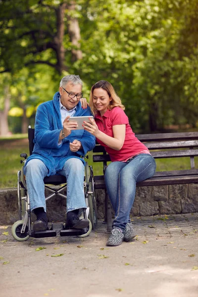 Engelli babası dijital tablet kullanma tekerlekli sandalye ve kızıyla