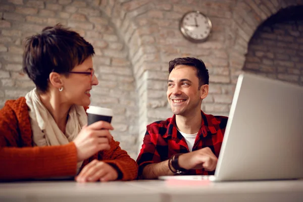Усміхнені дизайнерські люди працюють разом за столом на комп'ютері — стокове фото