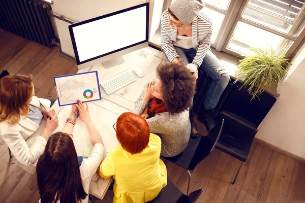 Женщины за творческой работой с графиком и компьютером в офисе, вид сверху — стоковое фото