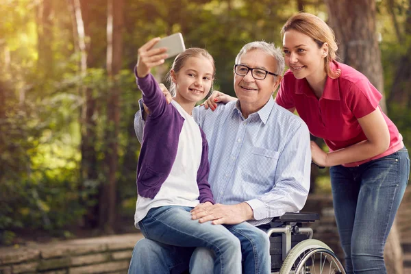 Дочка з батьком-інвалідом у інвалідному візку та онука — стокове фото