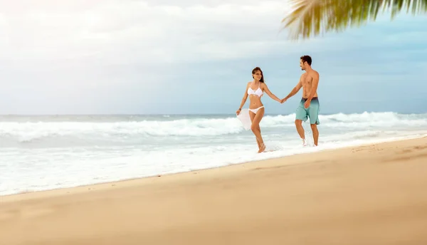 Любящая пара наслаждается и ходить по пляжу — стоковое фото