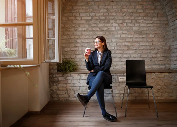 Vrouw zitten in de studio met kopje koffie — Stockfoto