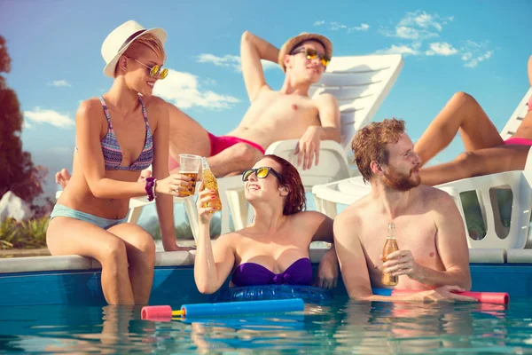 Brindisi delle ragazze con bevanda in piscina — Foto Stock