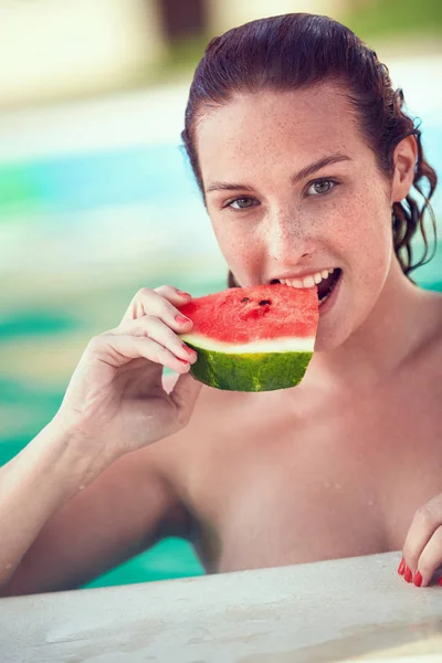 Bañista femenina refrescante en piscina con sandía —  Fotos de Stock