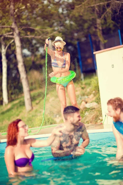 Grupo de mulheres e homens desfrutando na piscina na natureza — Fotografia de Stock