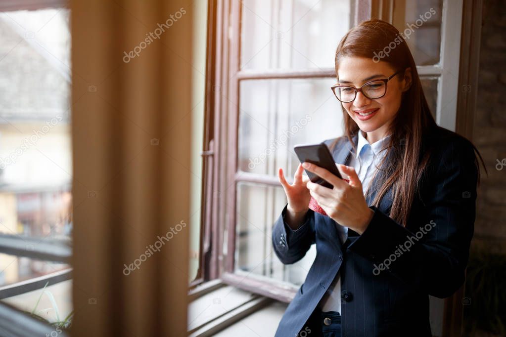 Smiling woman calling friends with cell phone