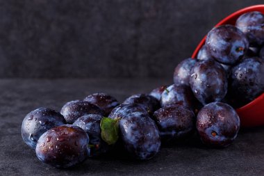 Karanlık tablo arka plan üzerinde taze olgun Erik