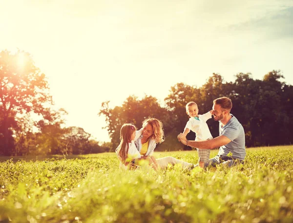 Male and female playing with children outside — Stock Photo, Image