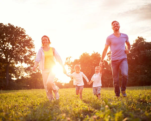 Moeder en vader met kinderen lopen in de natuur — Stockfoto