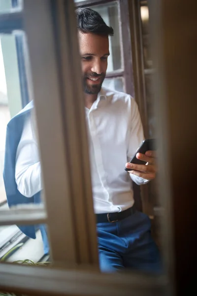 Homem no escritório chamando amigos no celular — Fotografia de Stock