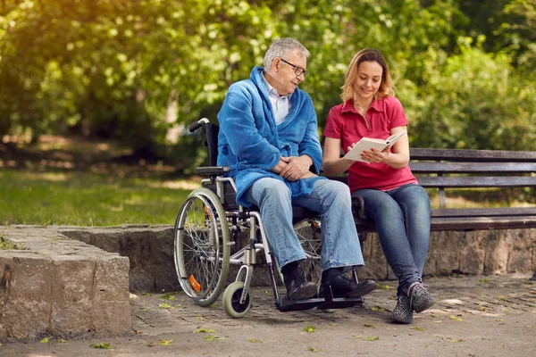 Zeit miteinander verbringen und im Freien Buch lesen Tochter und Behinderte — Stockfoto