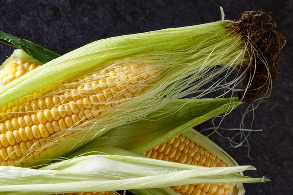 Fresh corn on cobs on black background — Stock Photo, Image