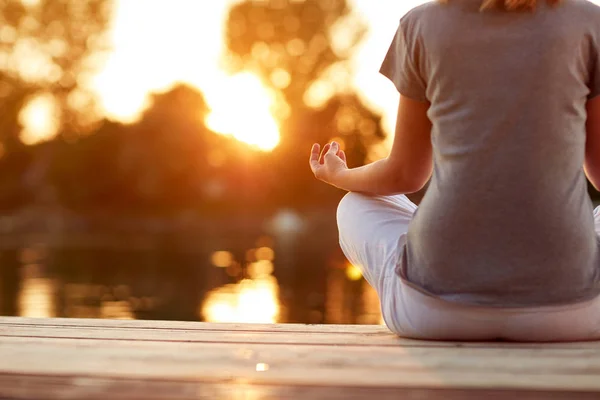 Yoga perto de água ao pôr-do-sol parte do corpo — Fotografia de Stock