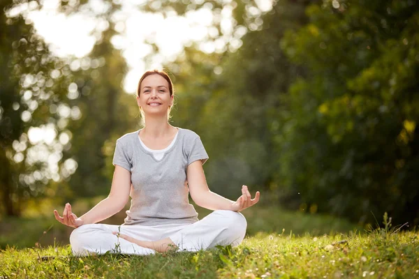 Mujer en yoga posan en la naturaleza — Foto de Stock