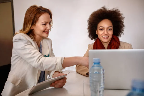 Gerente con el empleado hacer consultas sobre los negocios en el ordenador portátil — Foto de Stock