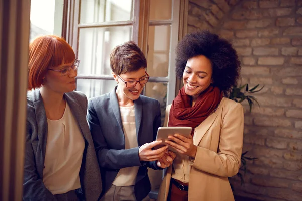 Collega's kijken tablet door venster — Stockfoto