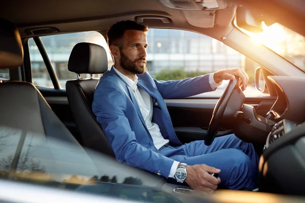 Attractive man in business suit driving car — Stock Photo, Image