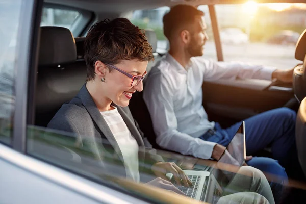 Kollegor arbetar tillsammans i baksätet på bilen — Stockfoto