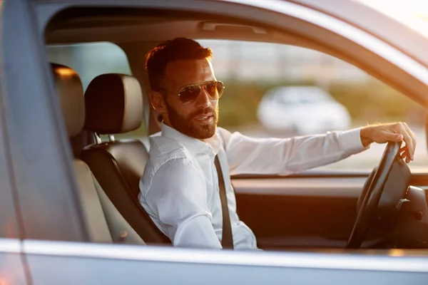 Elegante uomo d'affari che indossa occhiali da sole durante la guida auto — Foto Stock