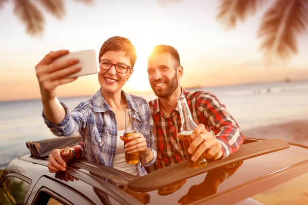 Amigos se divertindo enquanto bebe cerveja e tomar selfie — Fotografia de Stock