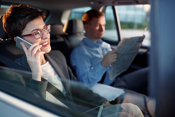 Jonge zakelijke vrouw gebruik smartphone in de auto — Stockfoto