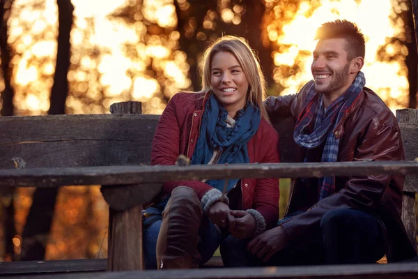 웃 고 있는 여자 친구와 남자 친구는 공원에서 벤치에 — 스톡 사진