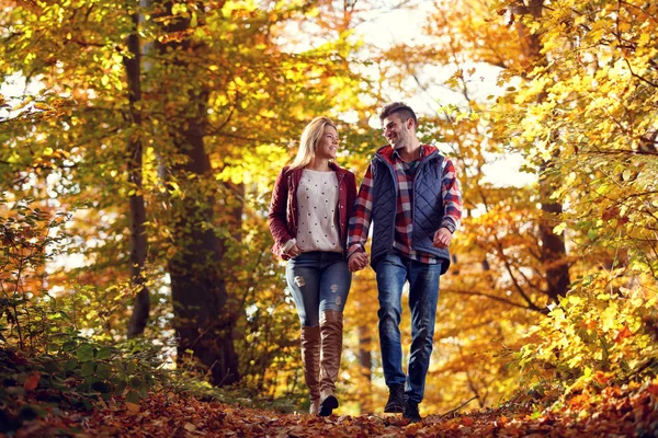 Lächelndes verliebtes Paar bei einem Spaziergang im Park an einem sonnigen Tag — Stockfoto