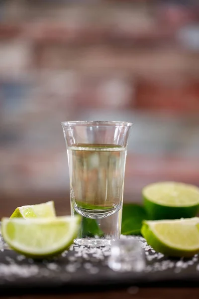 Tequila shot met zout, kalk en ijs achtergrond — Stockfoto