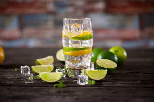 Cocktail frais avec eau gazeuse, glace, citron vert, orange et menthe — Photo