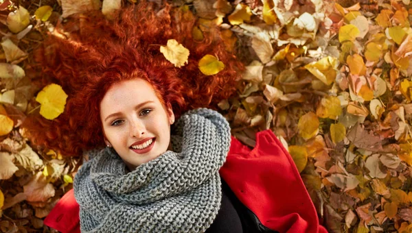 Gember vrouw liggend op Bladeren in het park — Stockfoto