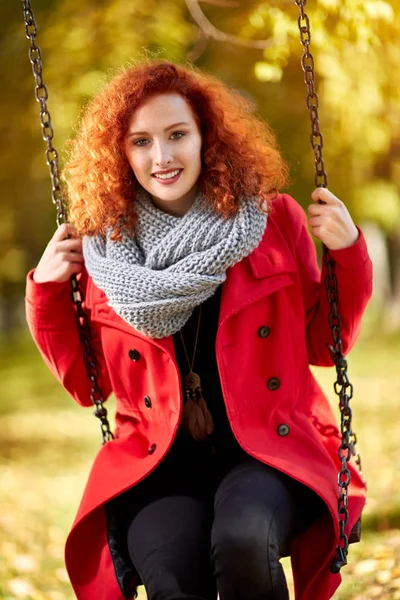 Czerwonych włosach kobiety na huśtawce — Zdjęcie stockowe