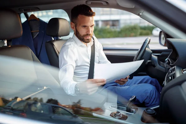 Ernstige man werken papierwerk in de auto — Stockfoto