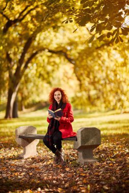 Park kitap ile kıvırcık kız