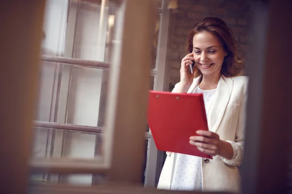 Žena ve studiu mluvit na mobilním telefonu s zaměstnance — Stock fotografie