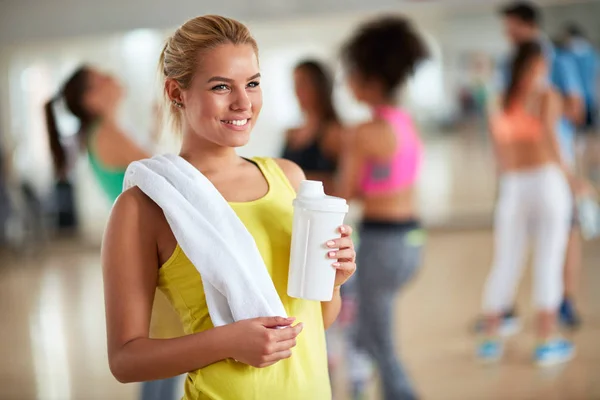 Mujer rubia después del entrenamiento con toalla y botella de bebida proteica —  Fotos de Stock