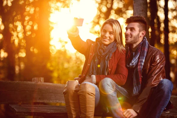 Miłość w parku - szczęśliwa para w parku biorąc selfie — Zdjęcie stockowe