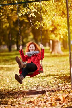 Parkta bir salıncak üzerinde sallanan dişi 