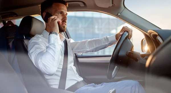 Ernstige zakenman in bewegende auto bezig met zijn laptop — Stockfoto