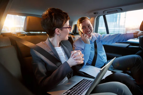 Seriös affärsman i flytta bilen fungerar på hans laptop — Stockfoto