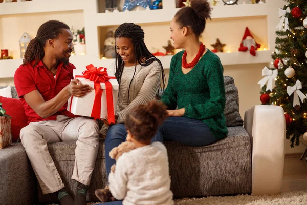 Glückliche Familie zusammen mit Weihnachtsgeschenk — Stockfoto