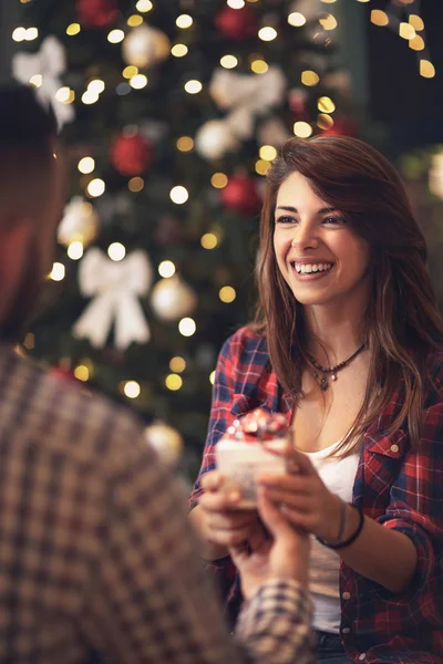 Lachende vrouw nemen van de gift van Kerstmis van man's hand — Stockfoto