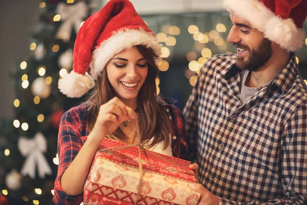 Man and woman opens Christmas gift — Stock Photo, Image