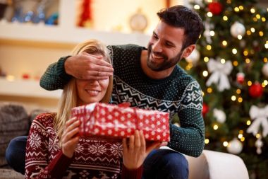 Mutlu bir adam kadınları el gözleri ile kapsar. adam bir hediye verir