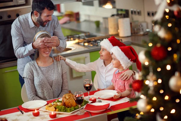 Far och barn överraskningar mor med familj julbord — Stockfoto