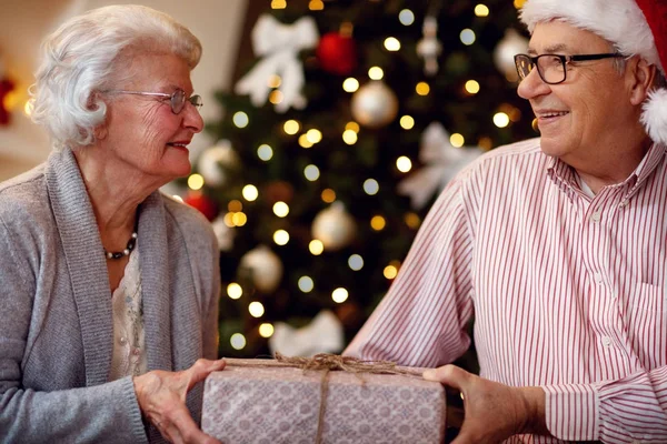 Familia, vacaciones, edad y concepto de personas - pareja mayor con regalo — Foto de Stock