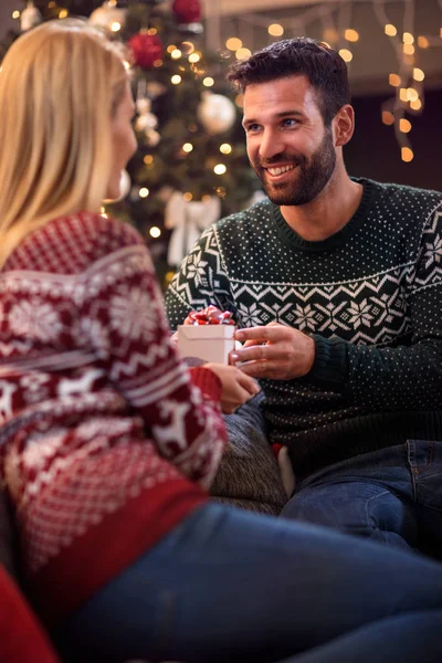 Charmant homme donnant cadeau de Noël à jeune femme heureuse — Photo