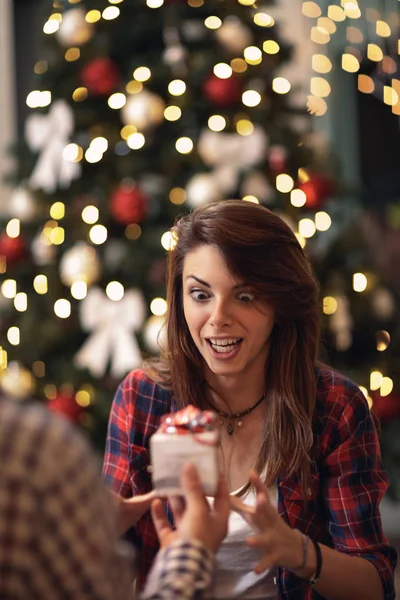 Mulher surpresa e curiosa recebendo presente de Natal — Fotografia de Stock