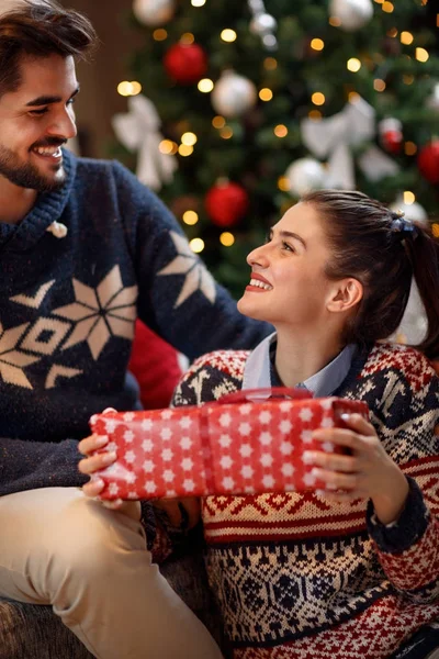 Закохана пара на різдвяну ніч ділитися подарунком — стокове фото