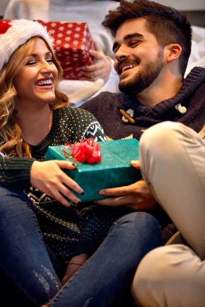 Casal trocando caixas de presente na véspera de Natal — Fotografia de Stock