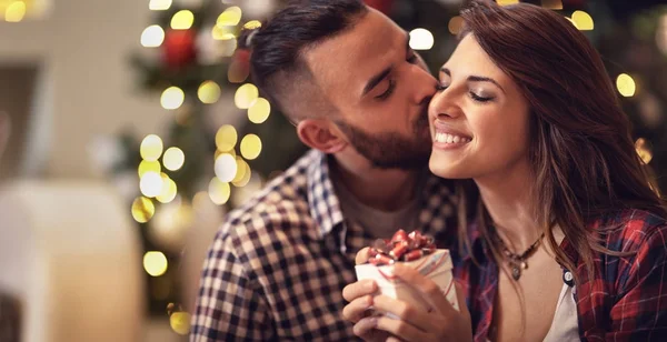 Uomo baci donna mentre dà il suo regalo di Natale — Foto Stock